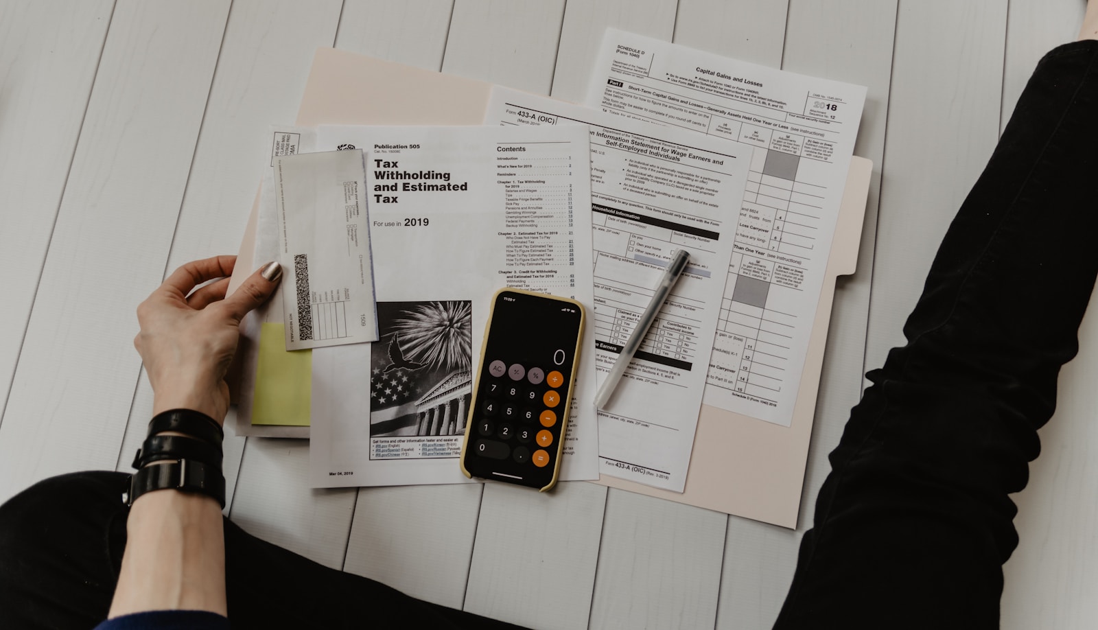 person holding paper near pen and calculator tax services